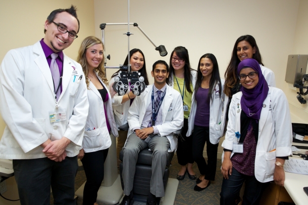 "A doctor in a freshly starched white clinic jacket is a commanding figure; taking his or her best care of a patient, a doctor can seem like a rock star to the uninitiated and aspiring pre-optometry student." MBKU students surround Dr. Raman Bhakhri for a great shot!